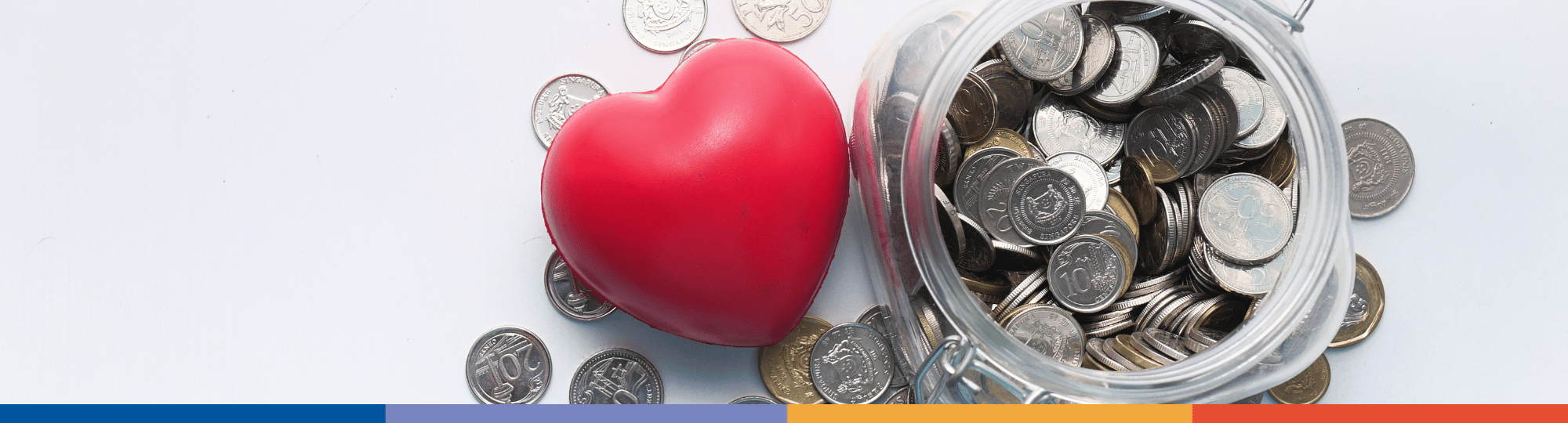 Photo of red heart with jar filled with coins